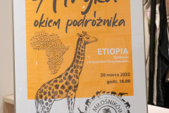 Na sztaludze plakat reklamujący spotkanie Afryka okiem podróżnika.