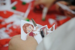 Dłonie kobiety wycinające dziewczynkę z papieru.