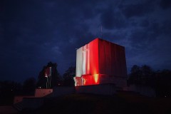 Biało-czerwona iluminacja na Pomniku Mauzoleum o zmroku.