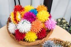 Koszyk wiklinowy pełen kolorowych jeżyków – ozdób choinkowych z papieru