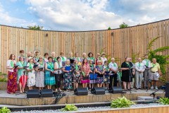 Chórzyści, ponad trzydzieści osób, stoją na scenie w tężni solankowej