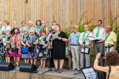 Chórzyści, ponad dwadzieścia osób, stoją na scenie w tężni solankowej