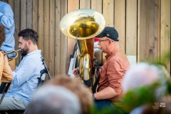 Tubista i trębacz siedząc grają na terenie tężni solankowej