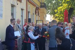 Ponad dwadzieścia osób stoi przed budynkiem