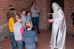 Grupa dzieci i Panie jedna pani przebrana za ducha w piwnicy w Muzeum.