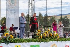 Dwóch mężczyzn i dalej dwie kobiety przy mikrofonach na scenie.