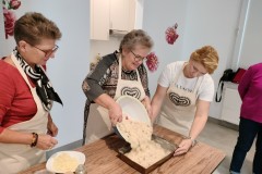 trzy kobiety wlewają ciasto do blaszki 
