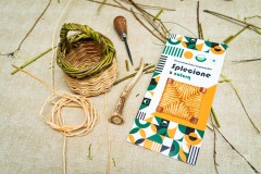 Koszyk z wikliny, obok materiały, szydło i folder z napisem Plecionkarstwo kurpiowskie Splecione z naturą.