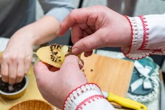 osoba robi ozdobę wbijając w plaster wosku goździki 