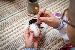 Dłonie wykonujące pisankę metodą batikową