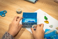 Dłonie wykonujące zdobione pudełeczko