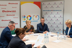 Uczestnicy konferencji siedzący pry stole