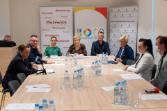 Uczestnicy konferencji siedzący pry stole