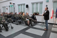 Mężczyzna stoi przy mikrofonie przed widownią w dziedzińcu muzealnym
