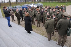 Kobieta stoi przed grupą osób przy Pomnik Mauzoleum Żołnierzy poległych w bitwie pod Ostrołęką 