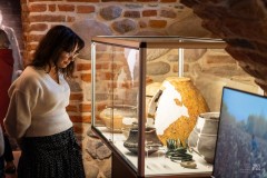 Kobieta ogląda zabytki archeologiczne w gablocie