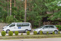 Samochody na parkingu obok wejścia do Zagrody Kurpiowskiej w Kadzidle