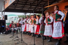 Zespół kobiet i mężczyzn w strojach kurpiowskich występujący na scenie