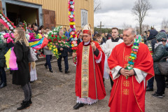 Procesja w Niedzielę Palmową. Na początku procesji idą księża w czerwonych ornatach niosący palmy wielkanocne.