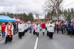 Procesja w Niedzielę Palmową. Na początku procesji idą księża. W tle uczestnicy niosący wysokie palmy wielkanocne