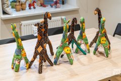 Osiem żyraf-przytulanek ustawionych na stole