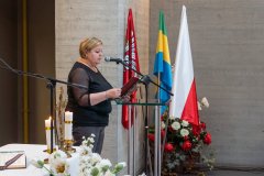 Kobieta czyta słowa Pisma Świętego podczas mszy w krypcie Pomnika Mauzoleum.