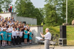 Dyrygent przed chórem występującym na schodach Pomnika Mauzoleum.