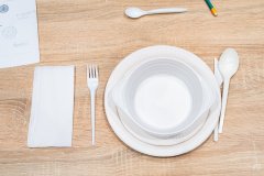 Plastikowa zastawa na blacie stołu. Widok z góry.