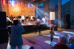 Artyści podczas występu na scenie, dzieci biegające przed sceną