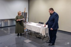Mężczyzna i kobieta stoją przy stole, na którym leżą książki
