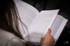 Dłonie trzymające kartkę czytanej książki