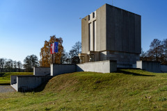 Pomnik Mauzoleum oraz w oddali, z lewej strony Pomnika maszty z flagami Mazowsza, Polski oraz Unii Europejskiej