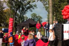 Uczestnicy imprezy plenerowej, w tle scena, dalej namiot typu pawilon