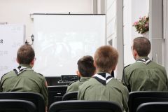 Czterech harcerzy ogląda wyświetlony film  na ekranie.
