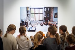 Kilkanaścioro dzieci ogląda duże zdjęcie na wystawie