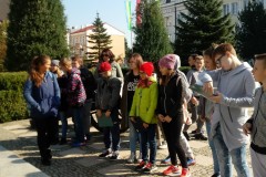 Grupa osób ogląda pomnik.