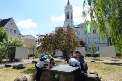 Dzieci rozwiązujące zadanie przy stoliku na dworze.