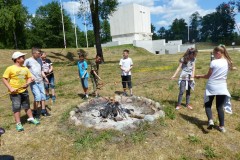 Dzieci pieką kiełbaski na ognisku
