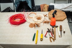 materiał i narzędzia plecionkarza  leżą na stole 