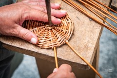 osoba robi podstawę kosza z wikliny