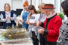 kilka osób stojąc przy stole wyplata z wikliny