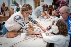 kobieta intrułuje dziecko jak ma wykonać ozdobę z wikliny