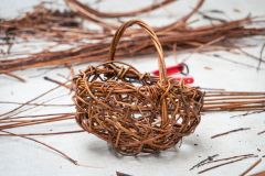 gotowy koszyk z wikliny, w tle ścinki wikliny