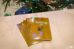 Pięć książek Wiktora Czajewskiego pt. „Kurpie”. Książki leżą na blacie ułożone w „wachlarz”. W tle niewielki fragment bożonarodzeniowej choinki.