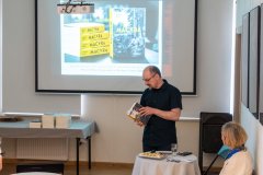 Stojący autor książki czyta uczestnikom fragment z książki.