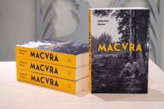 Na stoliku leżą promocyjne książki "Macvra"