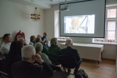 Widownia oglądająca filmik wyświetlany przez projektor 