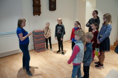 Kobieta opowiadająca i przeprowadzająca dzieci po muzeum