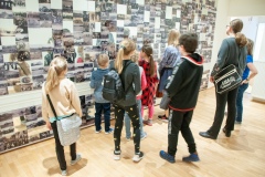 Kobieta opowiadająca i przeprowadzająca dzieci po muzeum