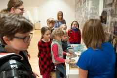 Kobieta opowiadająca i przeprowadzająca dzieci po muzeum
